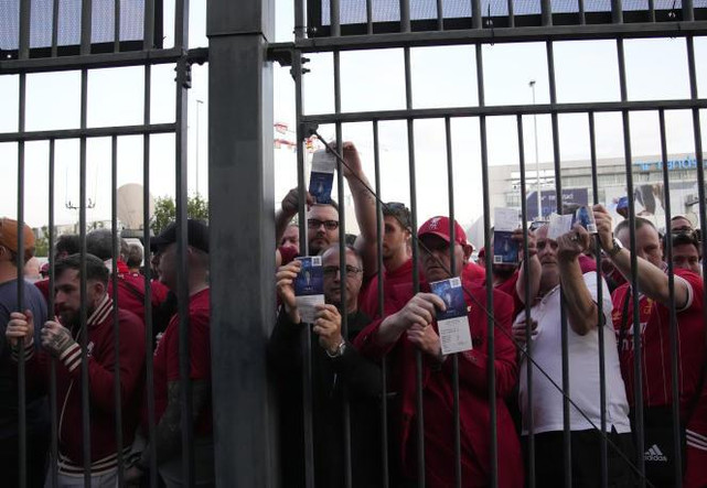 Des supporters de Liverpool  bloqués devant les grilles du Stade de France brandissent leurs tickets, à Saint-Denis (Seine-Saint-Denis), le 28 mai 2022.