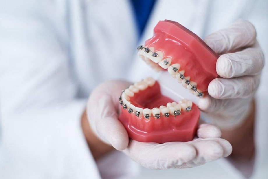 orthodontistholdingteethmodelwithbraces.jpg