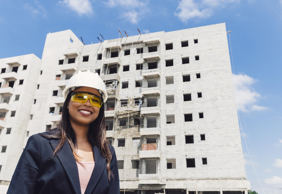 happyafricanamericanladysafetyhelmeteyeglassesnearbuildingconstruction.jpg